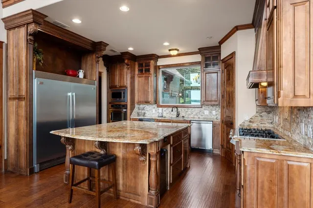 a kitchen with a stove a refrigerator and a dining table with wooden floor