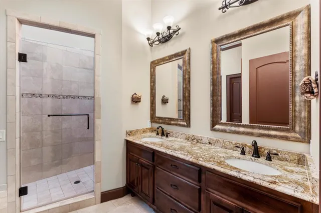 a bathroom with a granite countertop sink a mirror and a shower