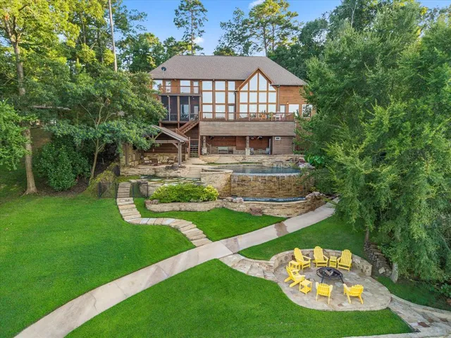 a view of a white house with a yard table and chairs
