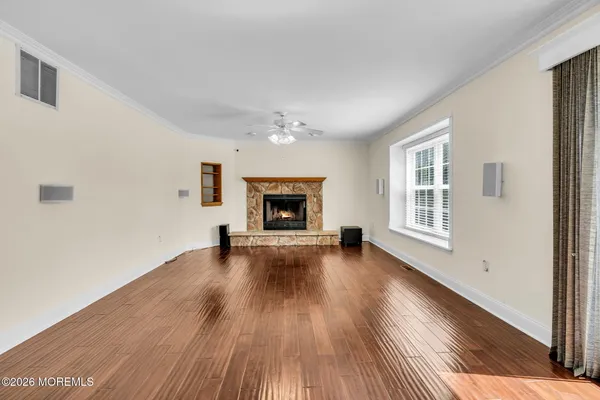 a view of empty room with wooden floor and fireplace