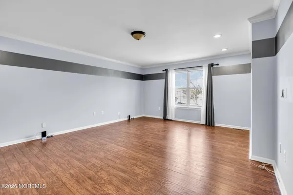 a view of an empty room with wooden floor