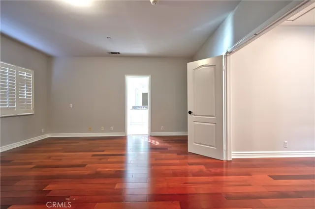 a room with walk in closet and wooden floor