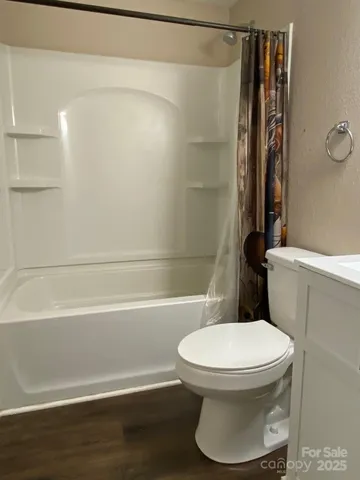 a white toilet sitting next to a bath tub and a shower