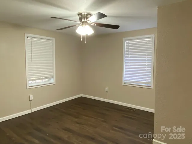 a view of a room with wooden floor and windows