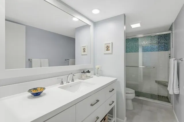 a bathroom with a sink a toilet and shower