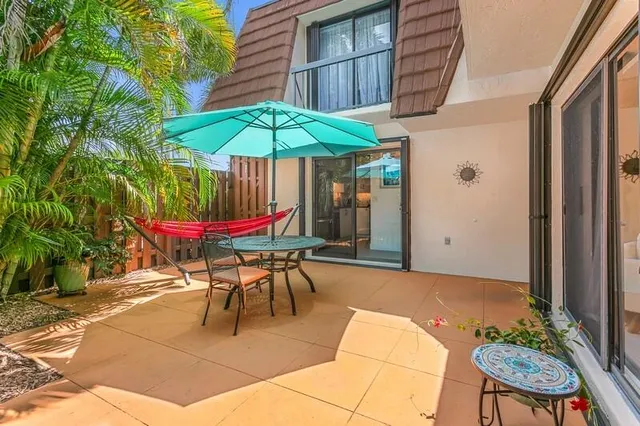 an patio with a table and chairs under an umbrella