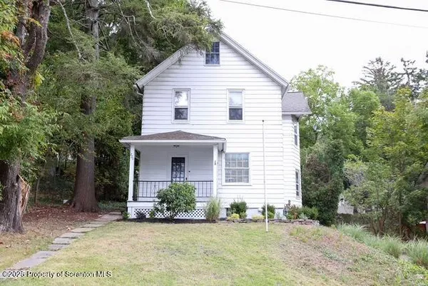 a view of a house with a yard and potted plants