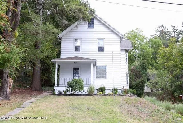 a view of a house with a yard and potted plants