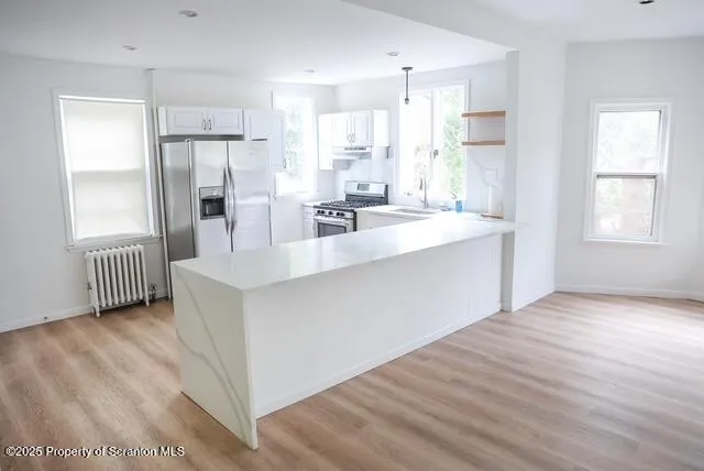 a view of a kitchen with furniture and wooden floor