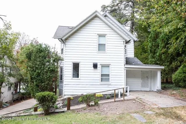 a view of a house with a yard and potted plants