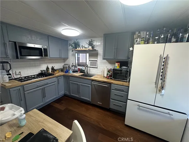 a kitchen with stainless steel appliances a refrigerator sink and microwave