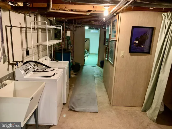 a bathroom with a granite countertop sink and a washing machine