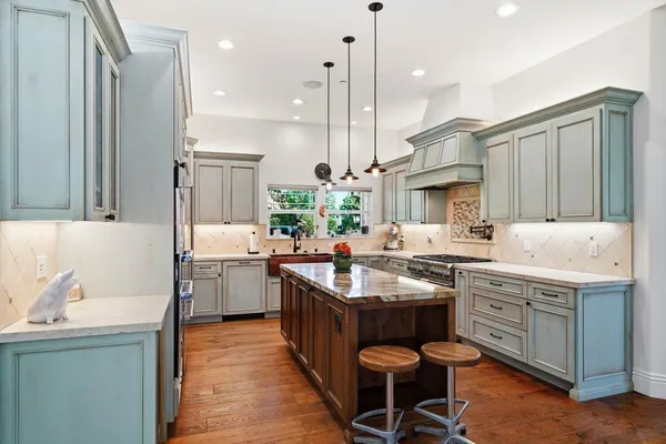 a kitchen with a stove a sink a dining table and chairs