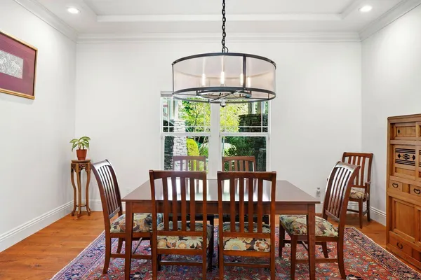 a dining room with furniture a chandelier and wooden floor