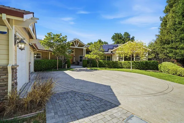 a front view of a house with a yard and trees
