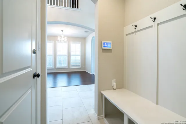 an empty room with windows and chandelier fan