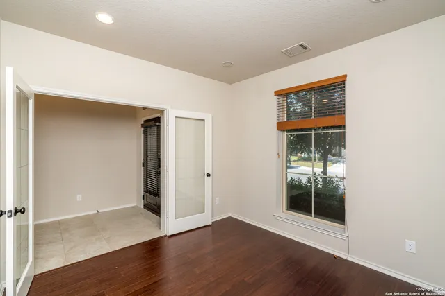 a view of a room with wooden floor and chandelier