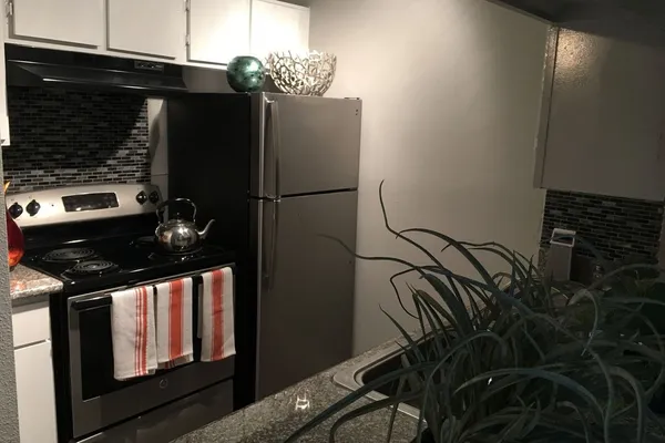 a kitchen with a refrigerator and a stove