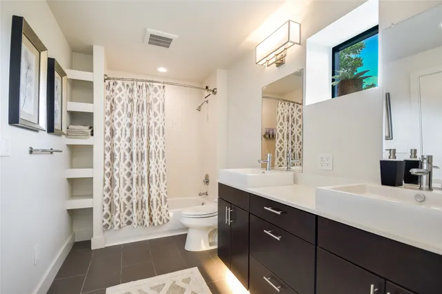 a bathroom with a double vanity sink toilet and shower