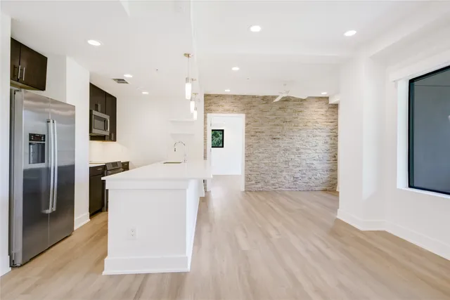 a view of kitchen with refrigerator cabinets and wooden floor