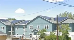 a front view of a house with a yard and potted plants