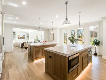 a view of a kitchen with granite countertop a stove a sink dishwasher with a dining table and chairs