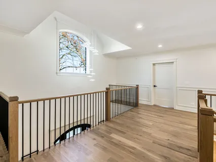 a bedroom with a large bed couch and wooden floor