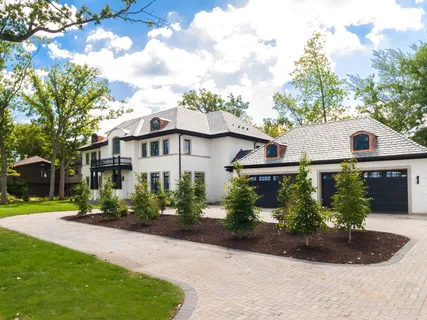 a big yard with lots of green space and trees all around