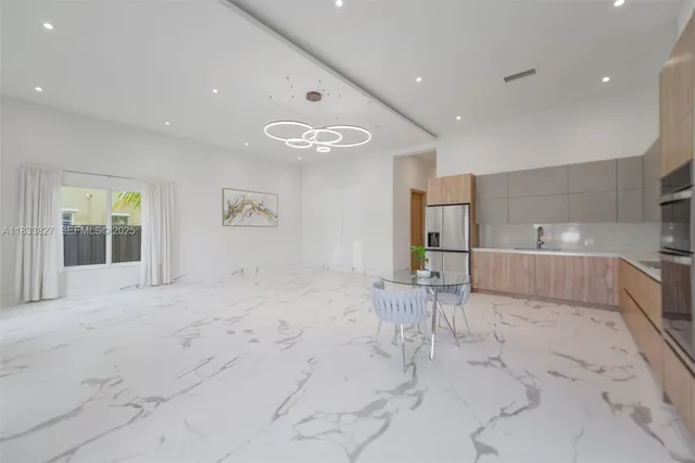 a kitchen with stainless steel appliances kitchen island granite countertop a refrigerator and a stove