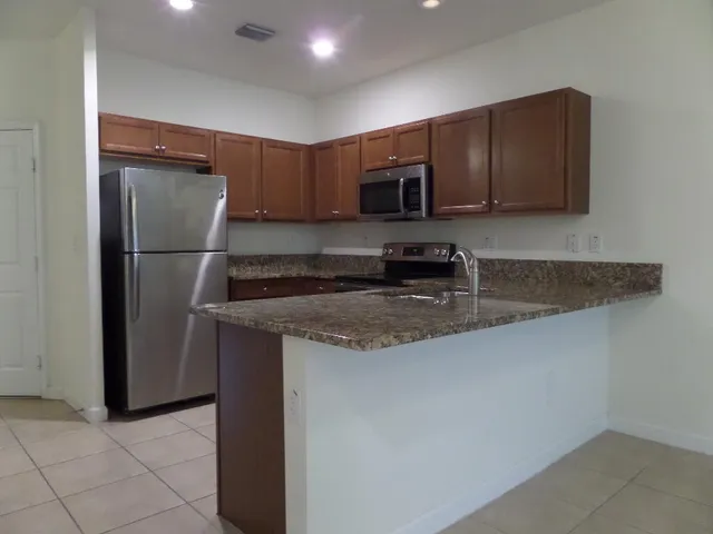 a kitchen with stainless steel appliances granite countertop a refrigerator and a sink