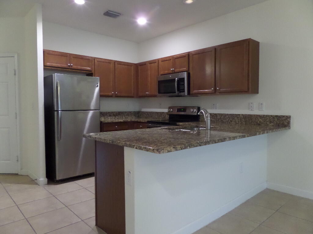 9328 West 33rd Way Hialeah, FL 33018 - Photo 5 of 24 a kitchen with stainless steel appliances granite countertop a refrigerator a stove a sink and a microwave