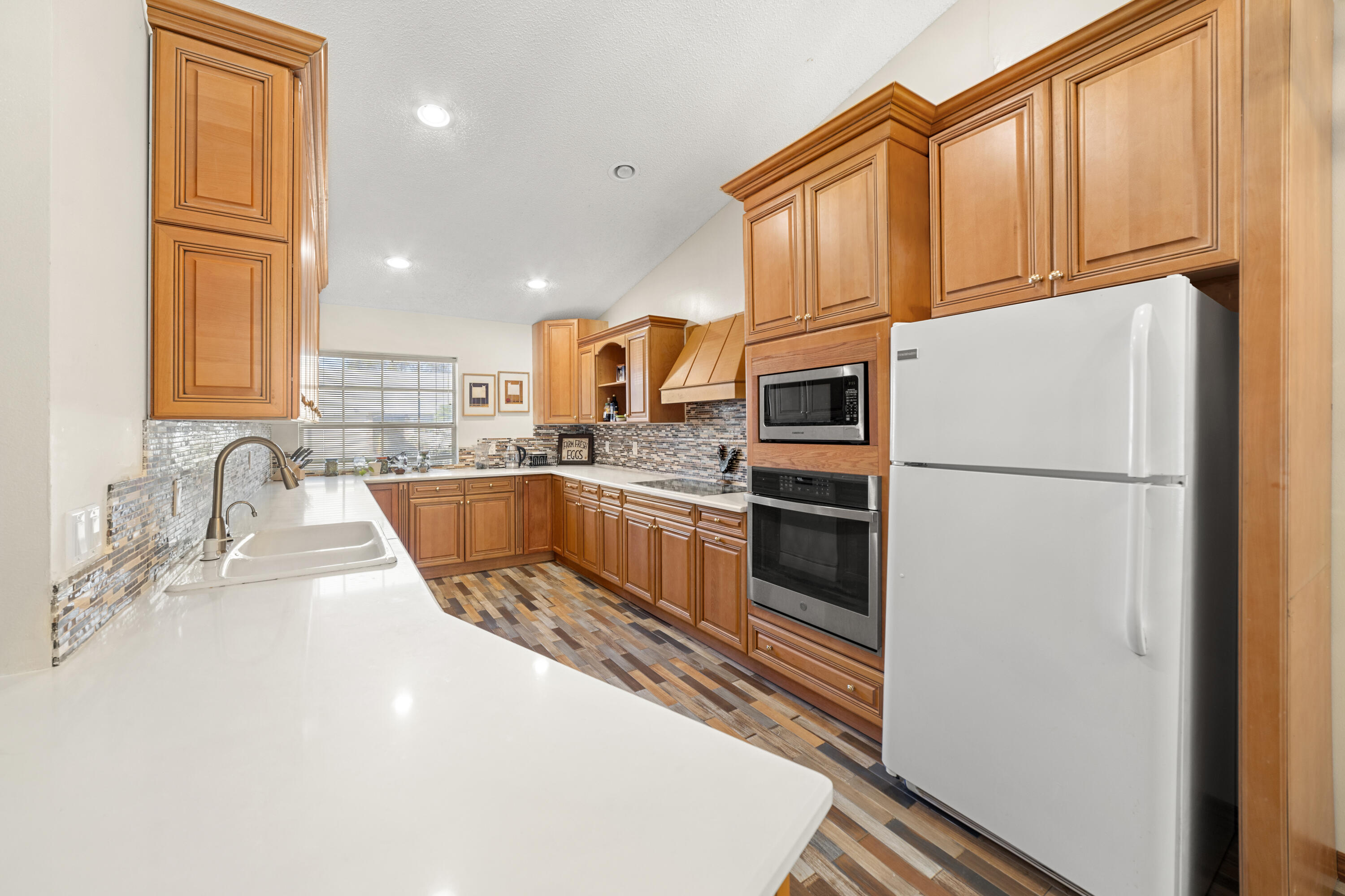 197 Bent Arrow Drive Jupiter, FL 33458 - Photo 9 of 33 a kitchen with stainless steel appliances granite countertop a refrigerator sink and cabinets