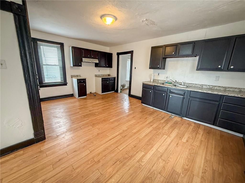 548 West Brady Street Butler, PA 16001 - Photo 7 of 36 a large kitchen with granite countertop a stove top oven a sink dishwasher and wooden floor