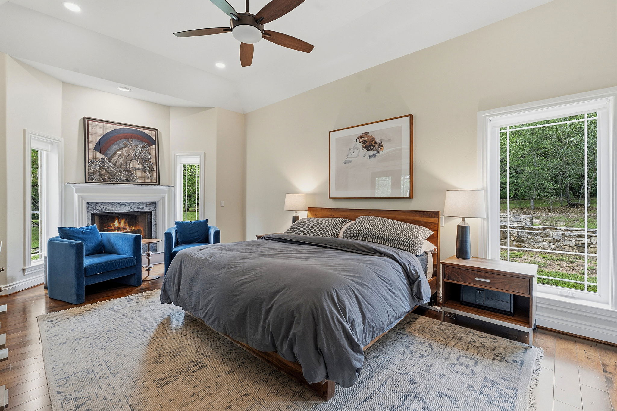 8121 Bluff Trail Austin, TX 78737 - Photo 24 of 40 A tranquil primary bedroom with vaulted ceilings, a cozy fireplace, and abundant natural light.