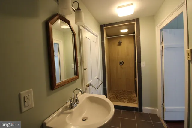 a bathroom with a mirror a sink and shower
