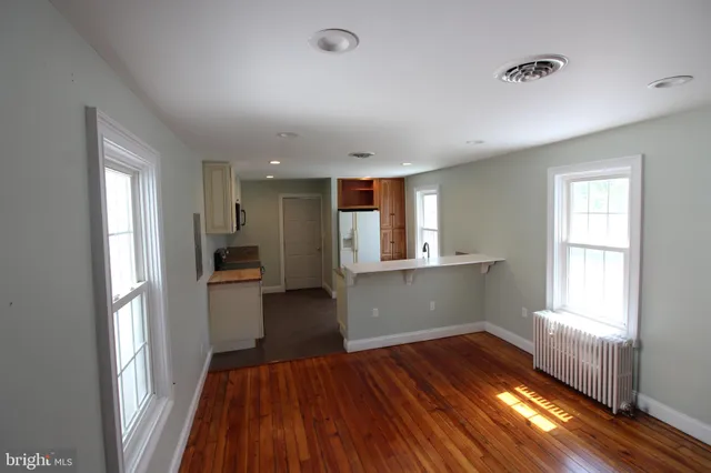 a kitchen with wooden floors and glass windows