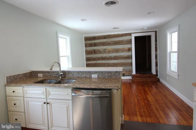 a kitchen with granite countertop a sink and a stove