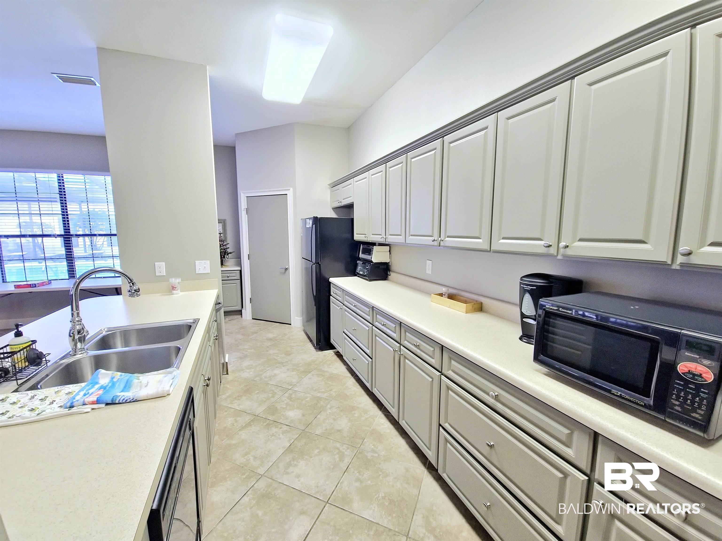 4650 Griffith Marina Road, Unit 12 Orange Beach, AL 36561 - Photo 21 of 34 Kitchen featuring light countertops, light tile patterned flooring, and black dishwasher