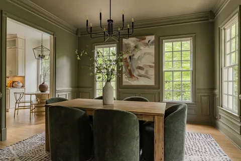 a kitchen with stainless steel appliances granite countertop a stove a sink a dining table and chairs with wooden floor