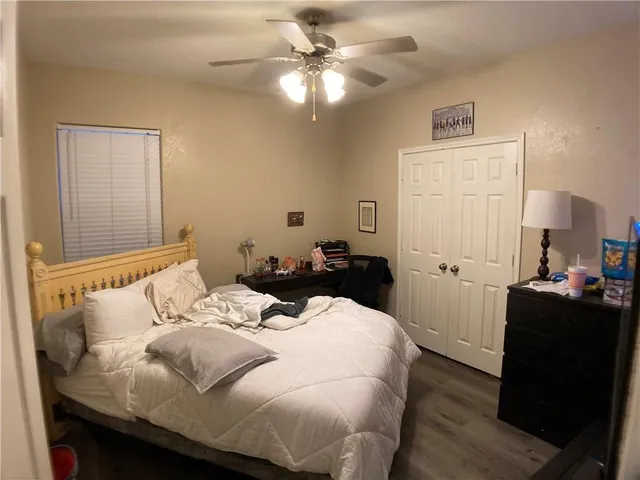 a bedroom with a bed and wooden floor