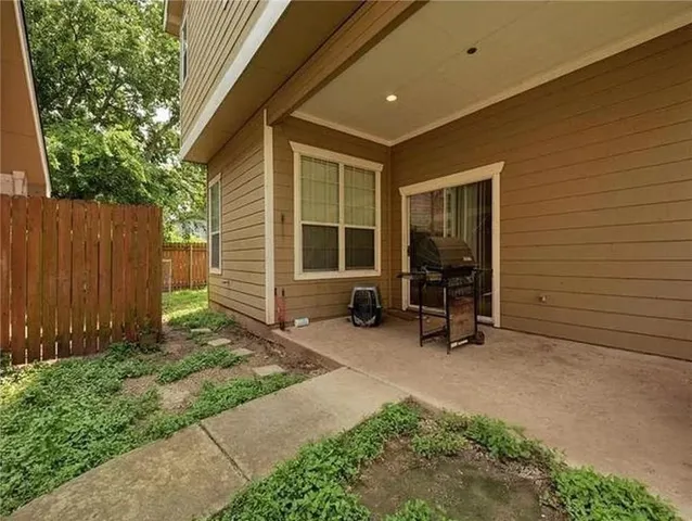 a view of a backyard with chairs and a large tree