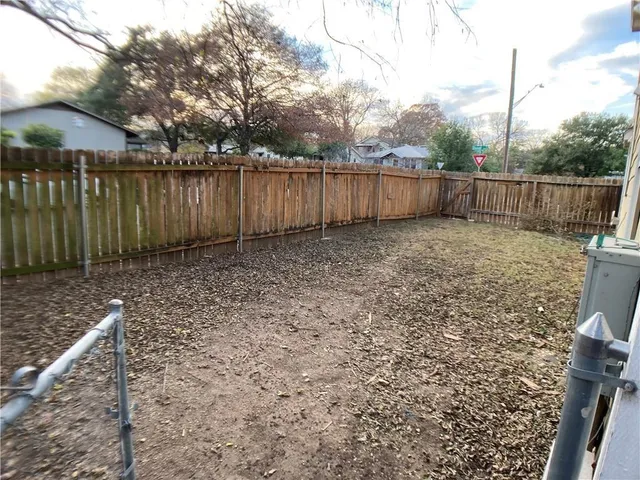 a view of a backyard with wooden fence