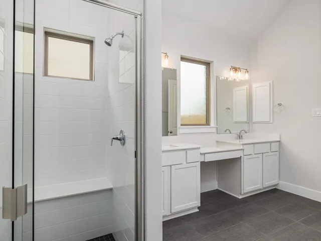 a bathroom with a double vanity sink mirror and bathtub