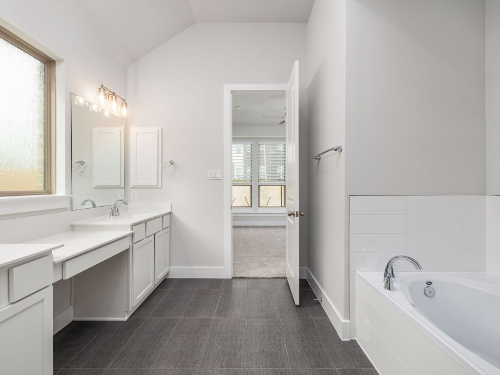416 Ridgewell Loop Georgetown, TX 78633 - Photo 12 of 19 a bathroom with a tub sink and mirror