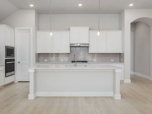 a view of kitchen with stainless steel appliances granite countertop cabinets and wooden floor