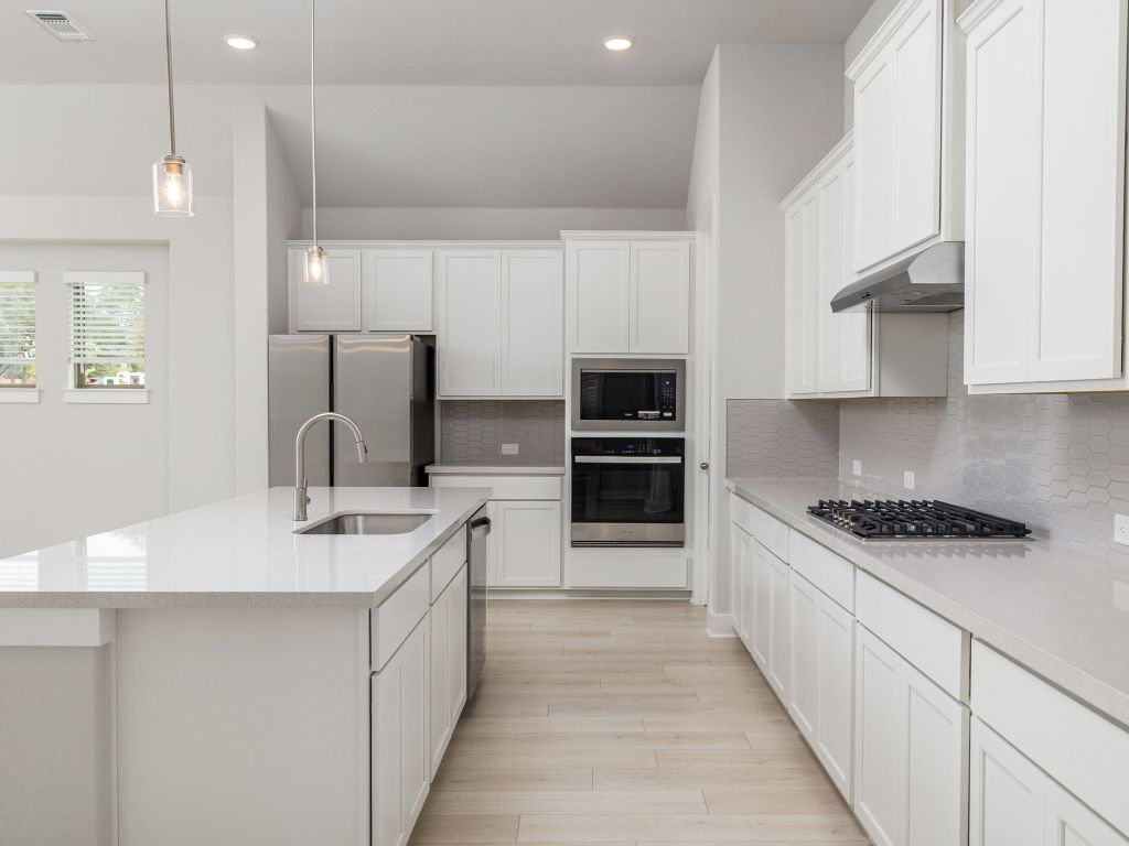 416 Ridgewell Loop Georgetown, TX 78633 - Photo 6 of 19 a kitchen with stainless steel appliances a sink stove and cabinets