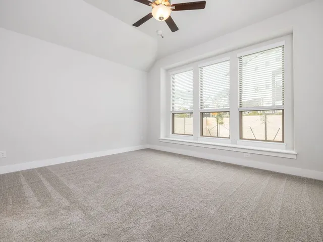an empty room with a window and a ceiling fan
