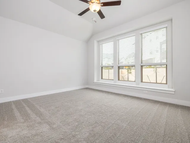 an empty room with a window and a ceiling fan