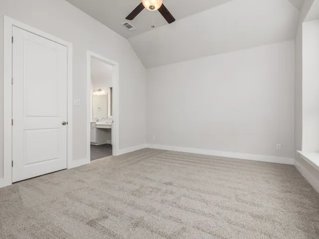 an empty room with ceiling fan and window