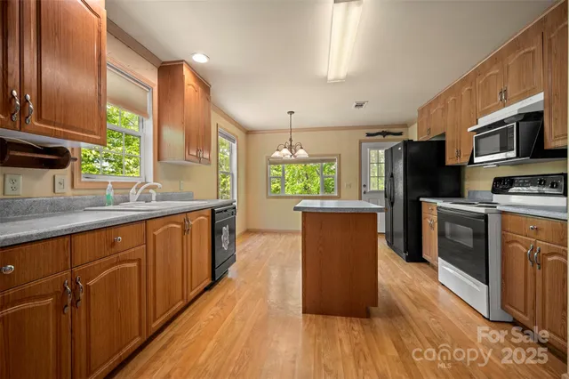 a kitchen with stainless steel appliances wooden floors and wooden cabinets